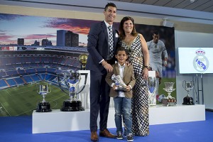 MADRID, SPAIN - OCTOBER 02: Cristiano Ronaldo poses for a picture with his trophy as all-time top scorer of Real Madrid CF held by his son Cristiano Ronald JR and his mother Maria Dolores dos Santos at Honour box-seat of Santiago Bernabeu Stadium on October 2, 2015 in Madrid, Spain. Portuguese palyer Cristiano Ronaldo overtook on his last UEFA Champions League match against Malmo FF Raul's record as Real Madrid all-time top scorer. (Photo by Gonzalo Arroyo Moreno/Getty Images)